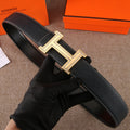 Black leather belt with textured finish and gold-tone H buckle