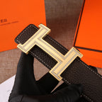 Hermes leather belt with dark brown strap and large gold H buckle, rhinestone edged