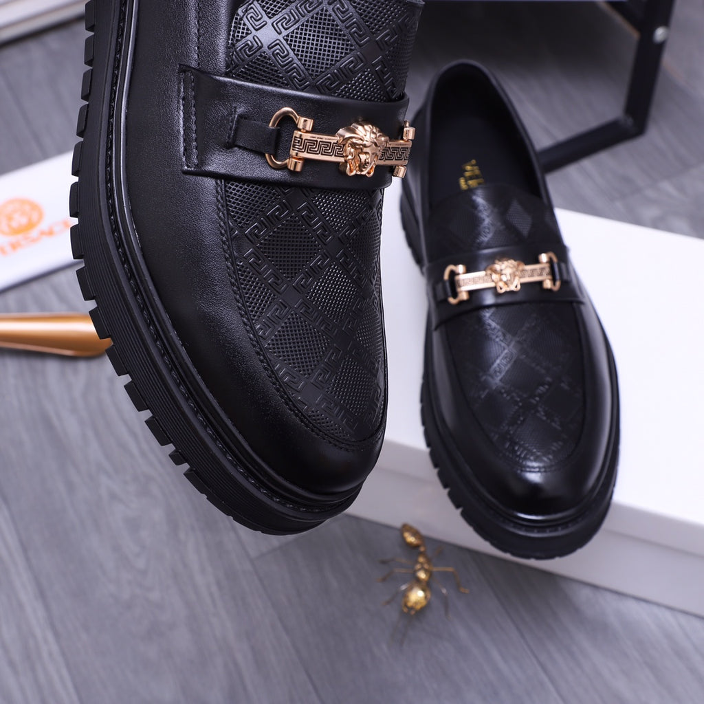 Versace luxury loafers close-up, black textured leather with gold buckle