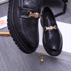 Versace luxury loafers close-up, black textured leather with gold buckle