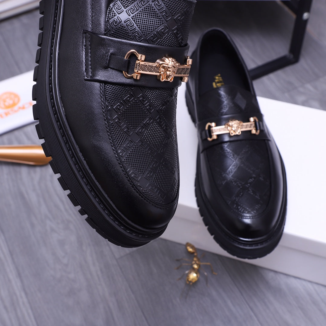 Versace luxury loafers close-up, black textured leather with gold buckle