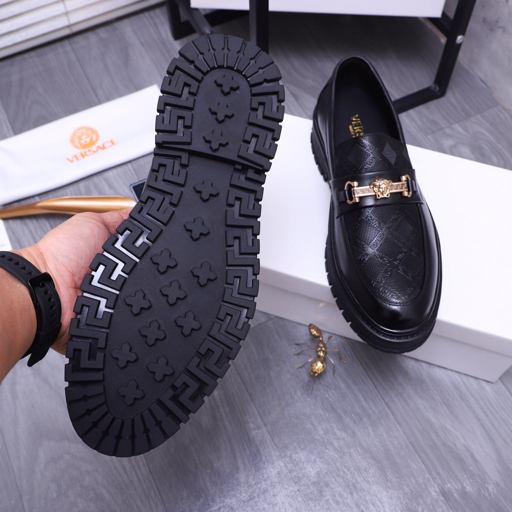 Versace luxury loafers outsole view, black tread with gold buckle strap front
