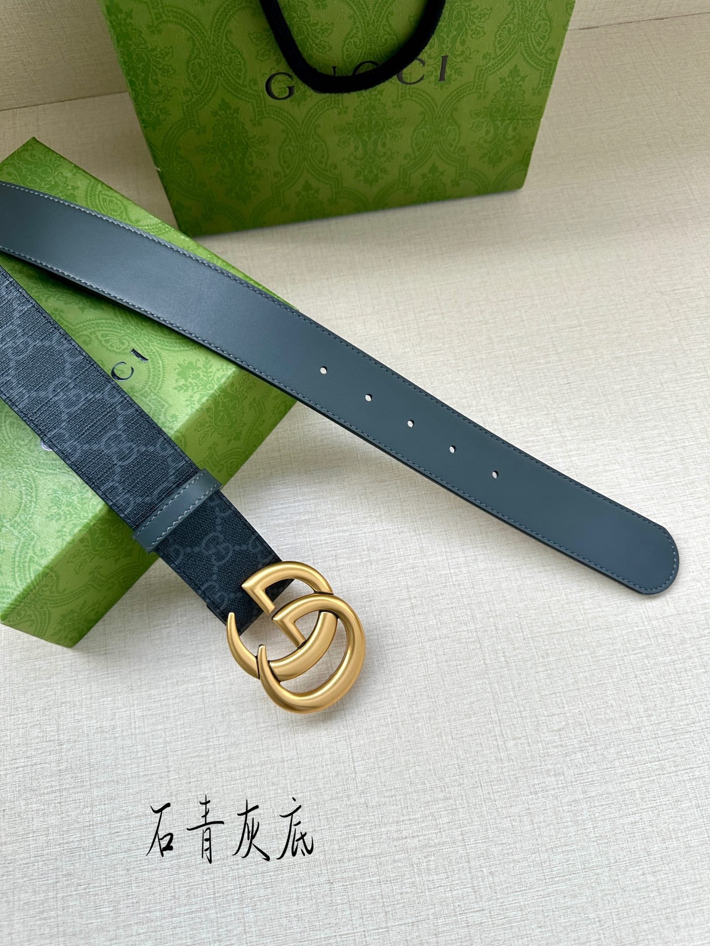 Gucci belt with dark blue monogram strap, gold-tone GG buckle, and belt holes