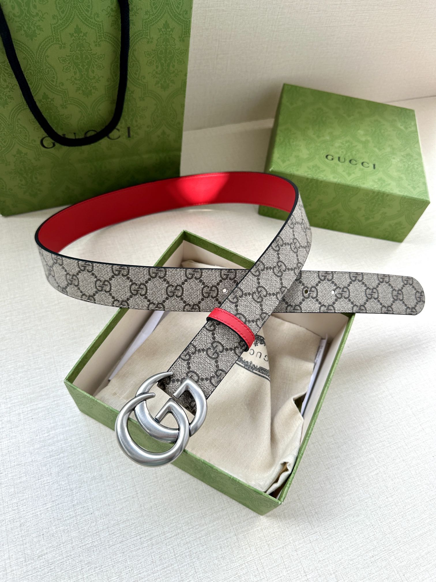 Gucci GG canvas belt with red trim and silver double-G buckle, looped