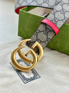Gucci GG canvas belt with red leather edge and gold double-G buckle, close-up