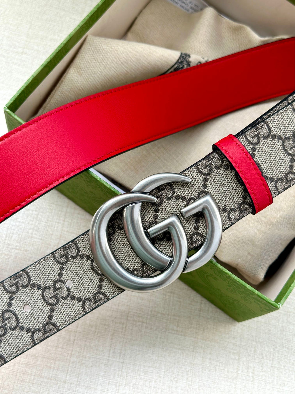 Gucci GG canvas belt with red leather strap and large silver double-G buckle