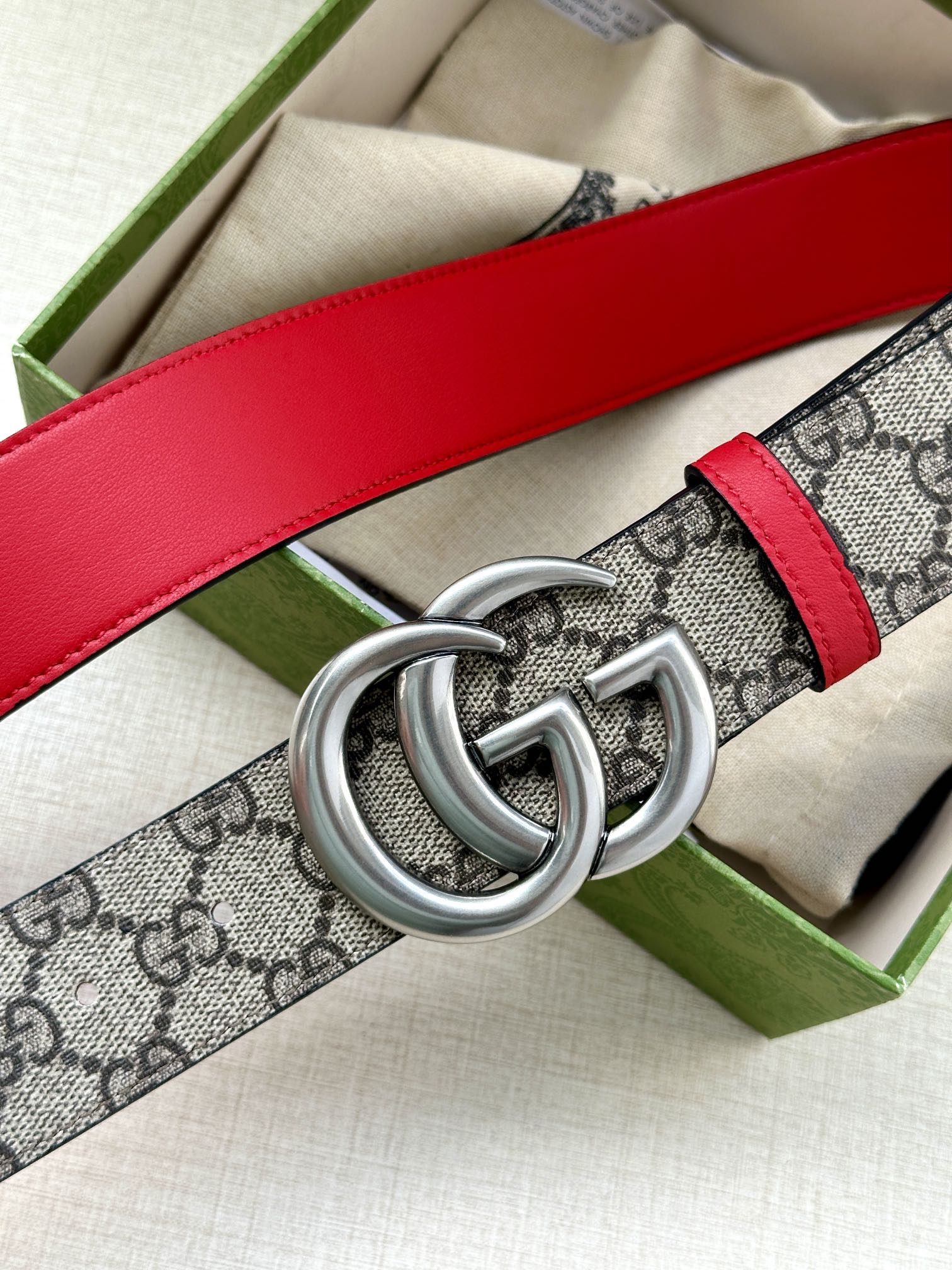 Gucci GG canvas belt with red leather strap and large silver double-G buckle