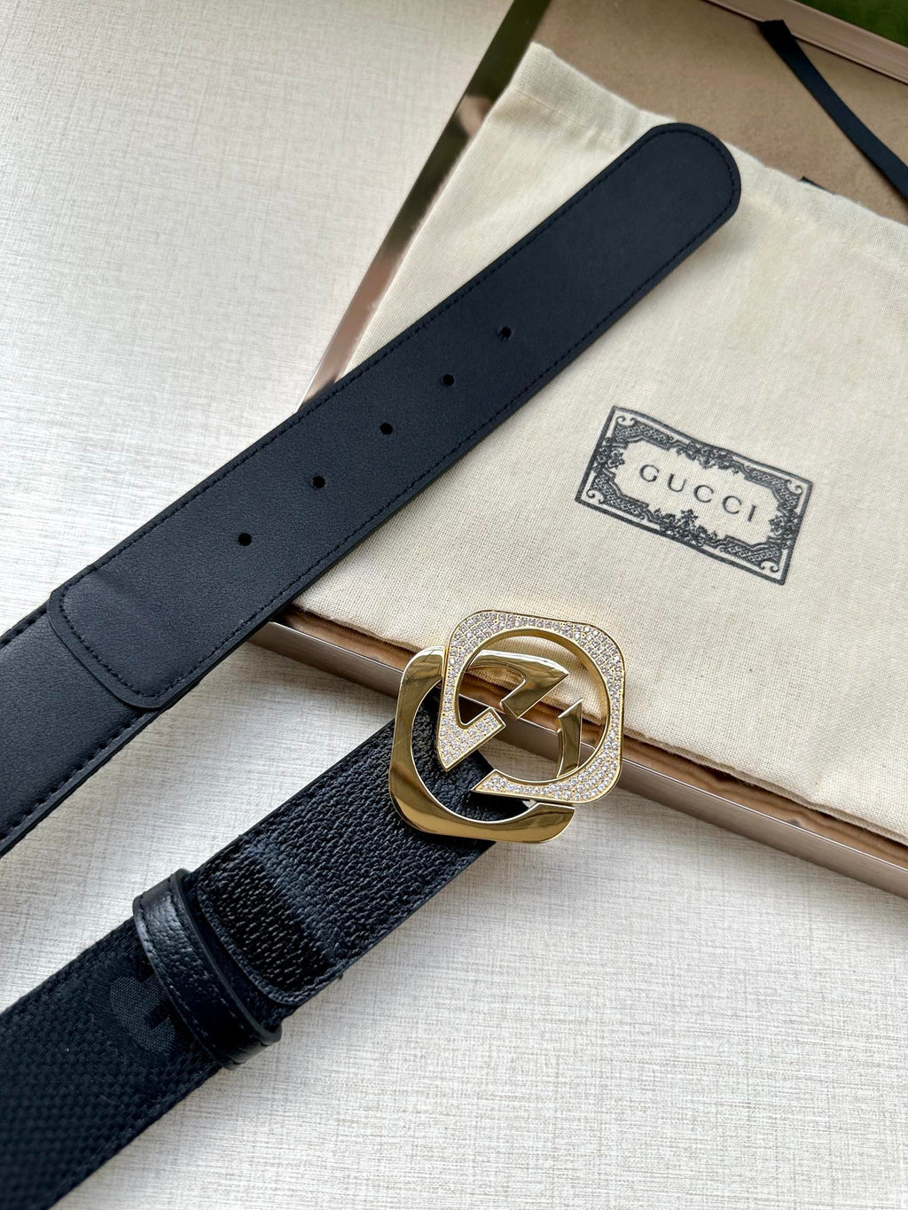 Dark navy leather belt with gold-tone GG logo buckle and perforated strap