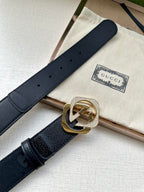 Dark navy leather belt with gold-tone GG logo buckle and perforated strap