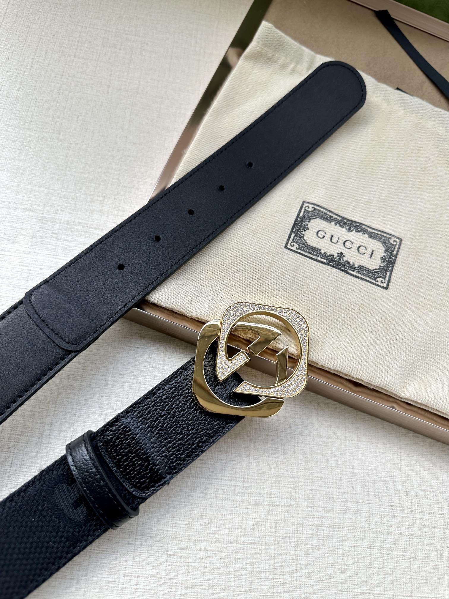Dark navy leather belt with gold-tone GG logo buckle and perforated strap