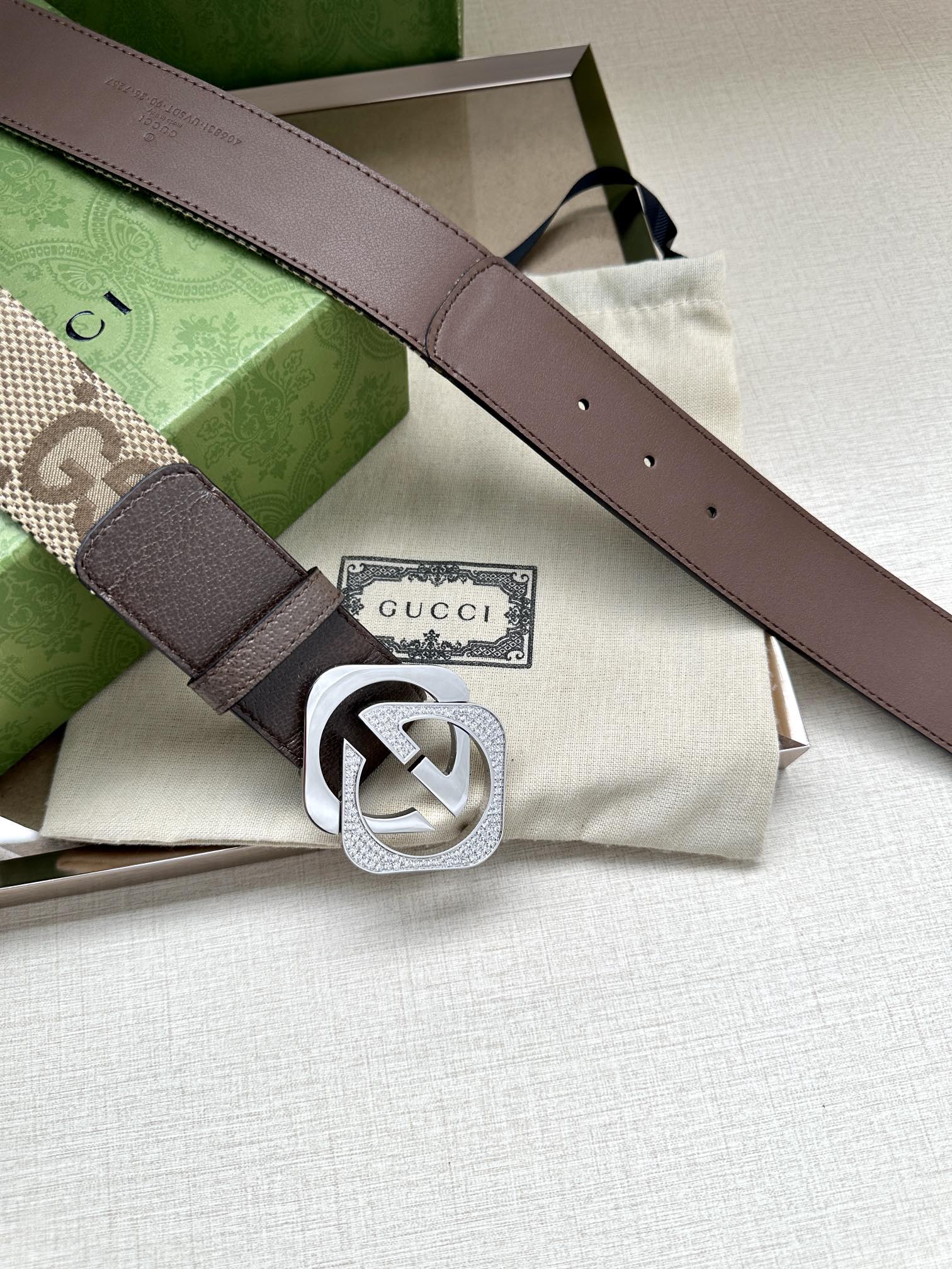 Gucci belt with dark brown leather strap and silver-tone GG logo buckle.