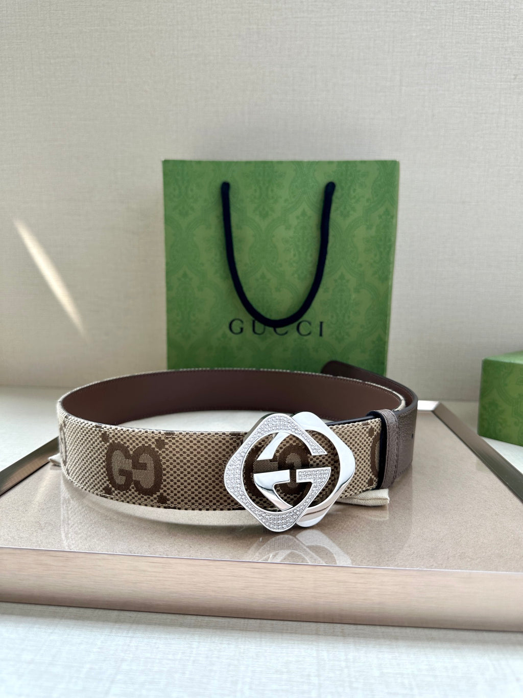Gucci belt with beige GG canvas strap and silver-tone buckle.