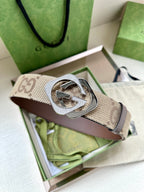 Gucci belt with beige GG canvas strap and silver-tone circular GG buckle.
