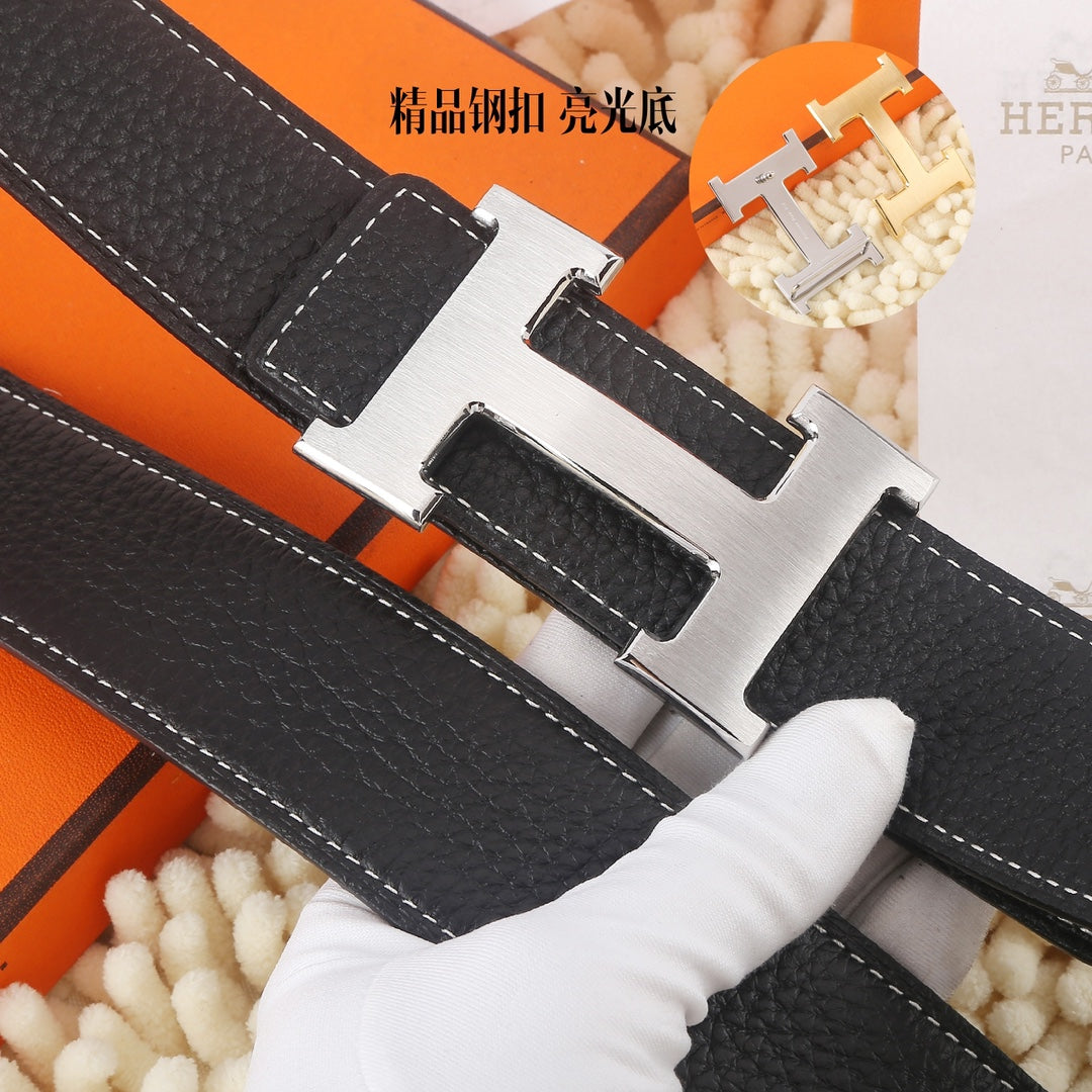 Black leather belt with silver buckle, close-up of topstitching