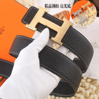 Black leather belt, gold-tone buckle, gloved hand close-up