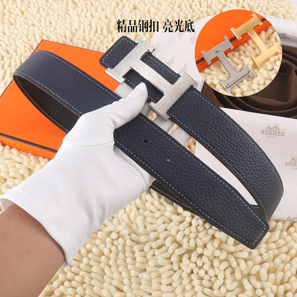 Navy leather belt with silver-toned H buckle and stitched strap, laid flat.