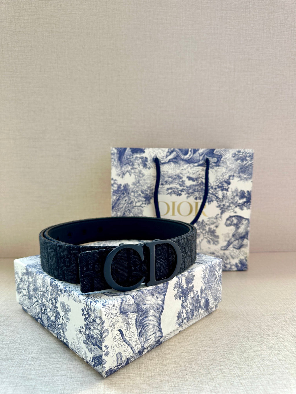 Designer belt in dark blue with large gunmetal buckle, flat on box