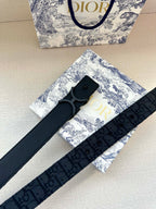 Dark blue fabric belt with repeating logo pattern and large buckle, laid diagonally
