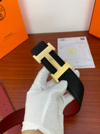 Hermes reversible leather belt, close-up black strap with gold-tone H buckle