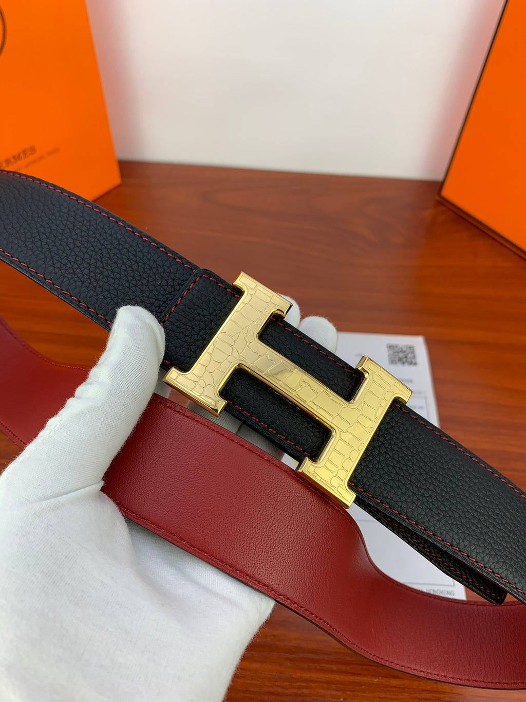 Hermes reversible leather belt, close-up black strap with gold-tone H buckle