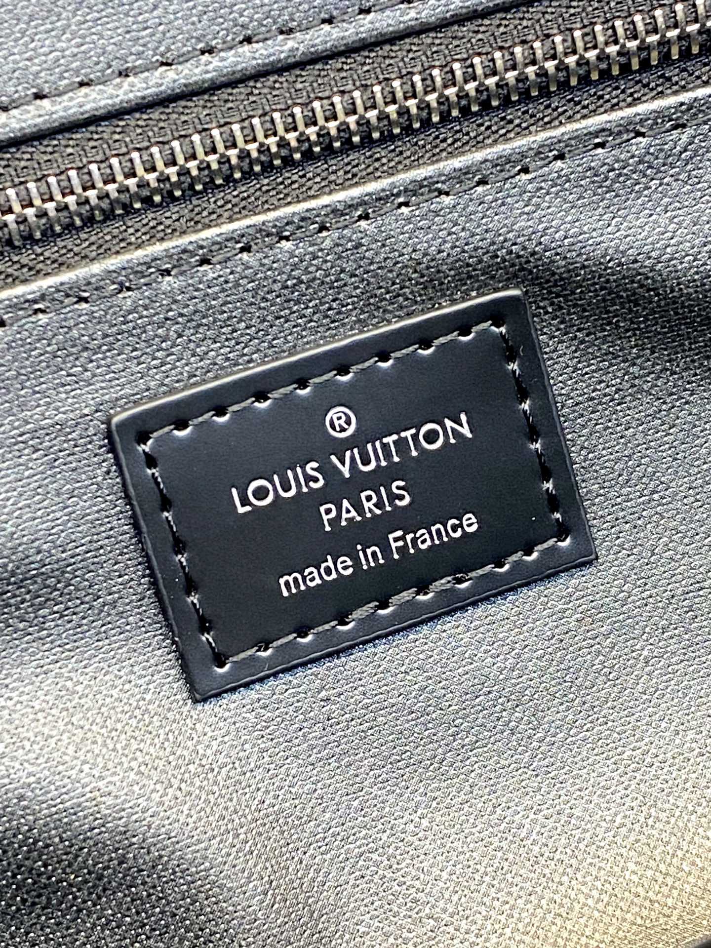 Louis Vuitton Paris logo leather patch on blue fabric with stitched edge