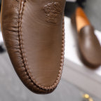 Versace brown leather loafer vamp close-up with embossed face emblem and stitching