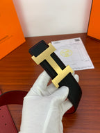 Black leather belt close-up with gold-tone H buckle and red lining