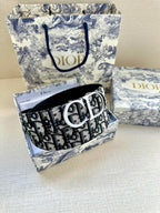 Dior belt with monogram strap and silver double-D buckle, coiled for storage