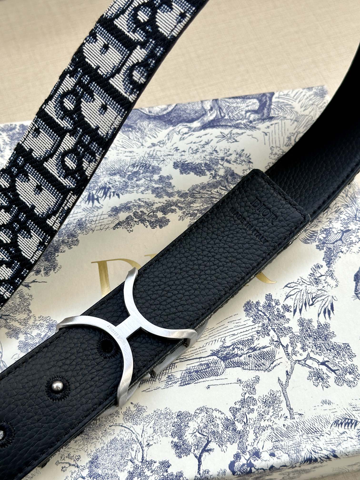 Dior belt detail with black textured leather strap and silver double-D buckle