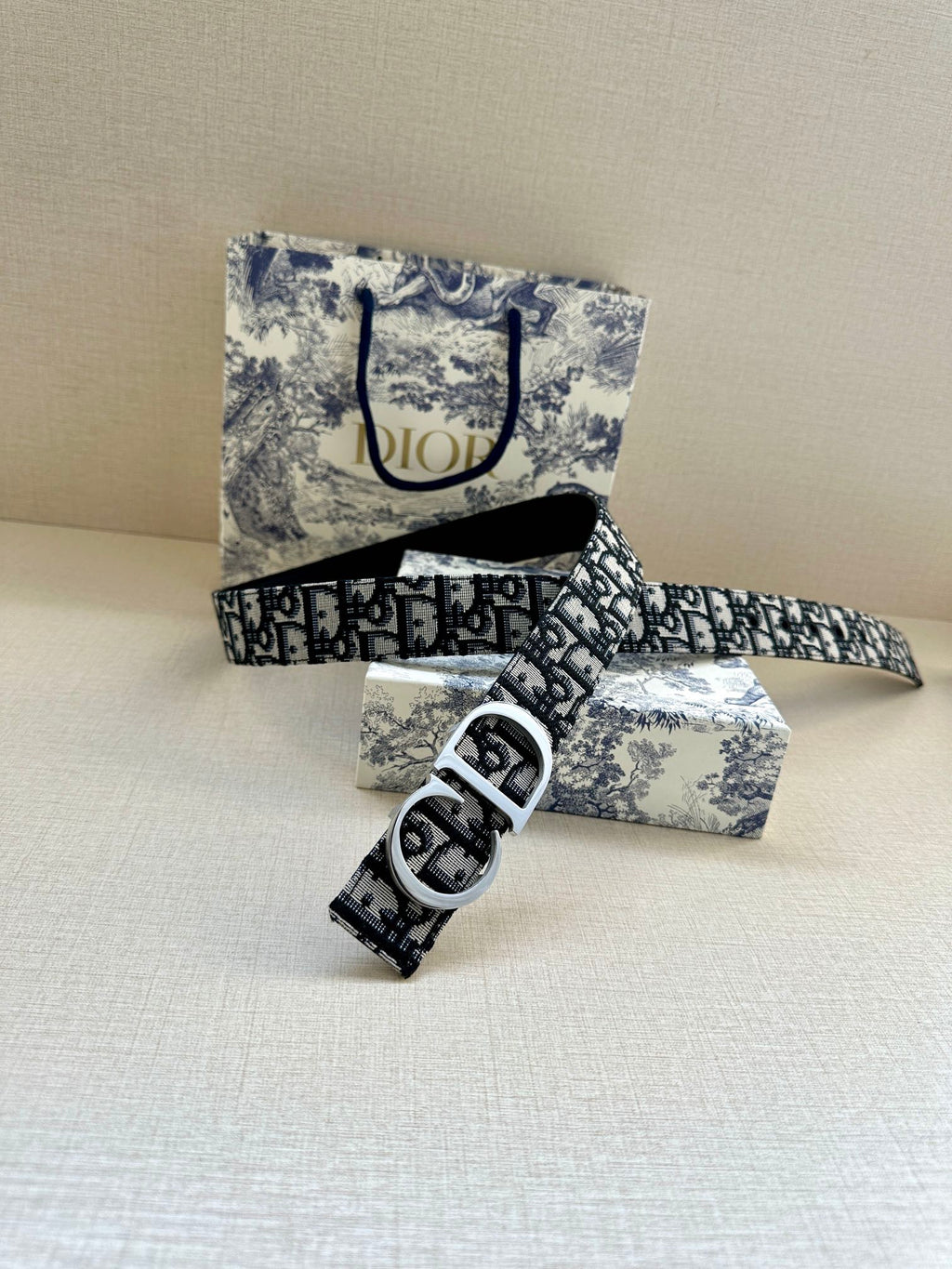 Dior belt with patterned strap and silver double-D buckle, folded end visible