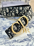 Dior belt close-up: navy-and-white logo jacquard strap with gold CD buckle