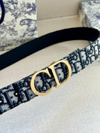 Dior belt close-up: navy-and-white logo jacquard strap with gold CD buckle