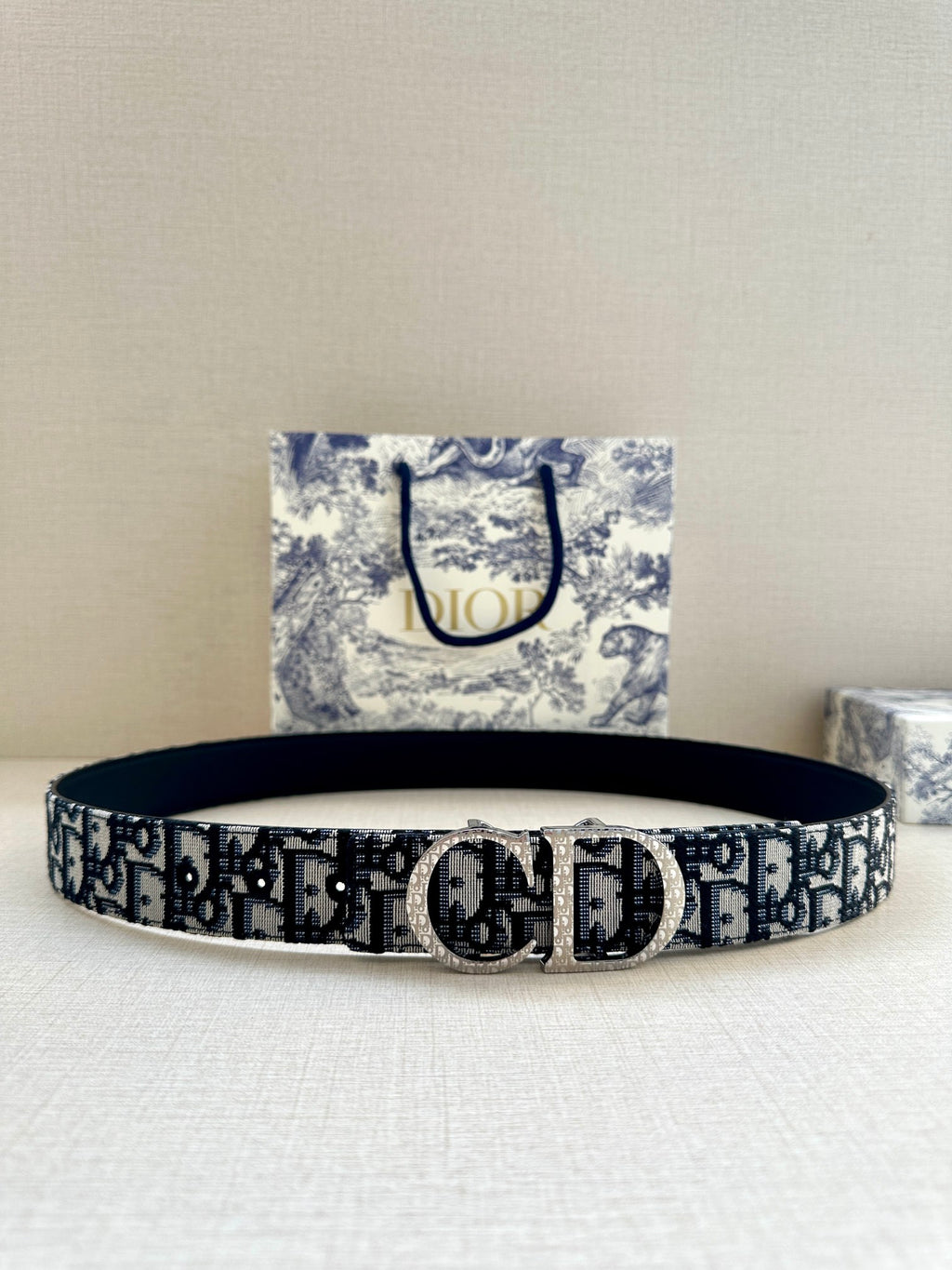 Dior belt with dark blue/black logo pattern and silver-tone buckle.