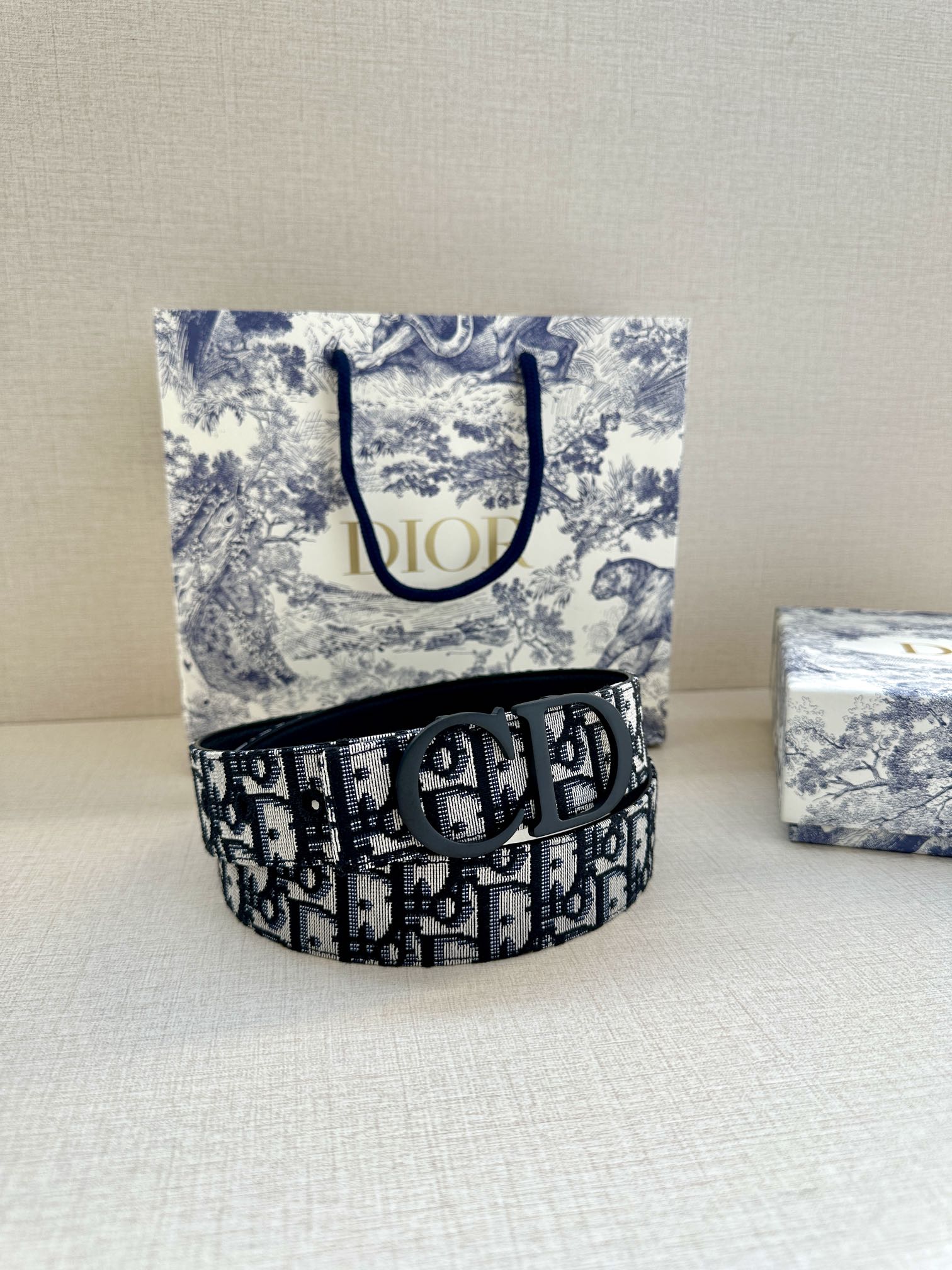 Dior belt, navy monogram strap with black buckle on patterned box