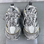 Balenciaga unisex sneakers front view, silver uppers with black logos and neon yellow accents.