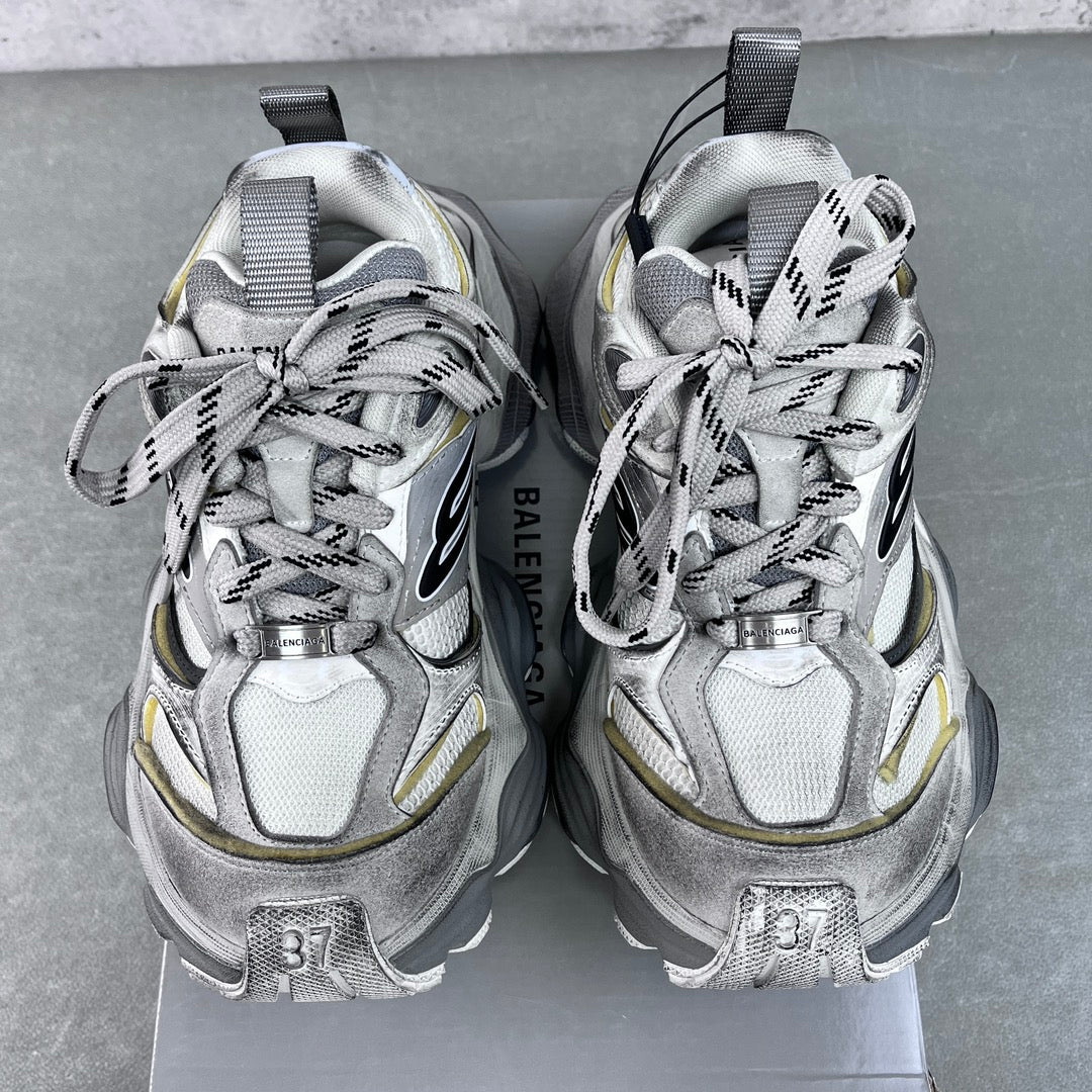 Balenciaga unisex sneakers front view, silver uppers with black logos and neon yellow accents.