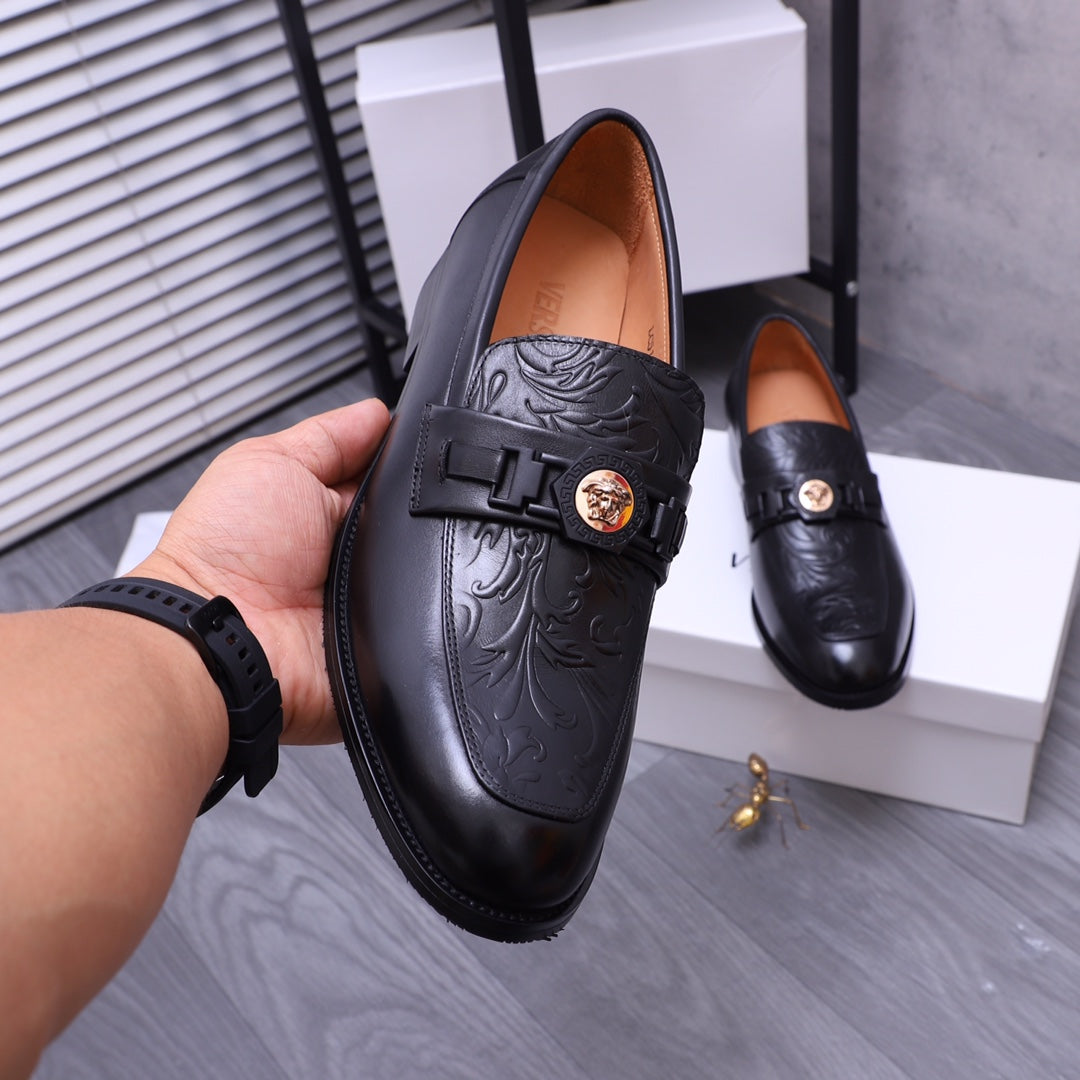 Versace black leather loafer with embossed upper and buckle strap, single shoe close-up