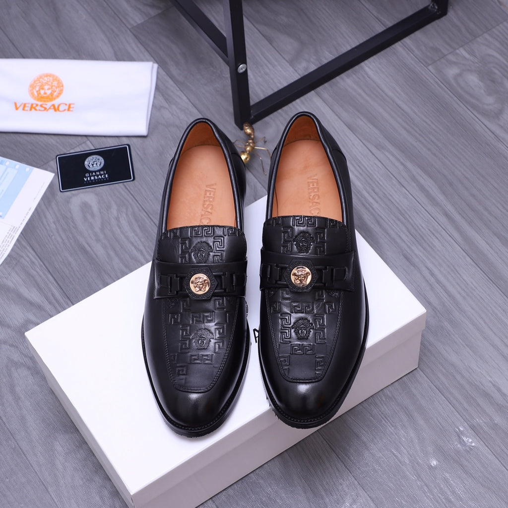 Black Versace loafers with embossed pattern and gold crest buckle, pair