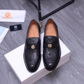 Black Versace loafers with embossed pattern and gold crest buckle, pair