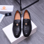 Black Versace loafers with embossed pattern and gold crest buckle, pair