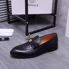 Black Versace loafer with strap and gold crest accent, side view