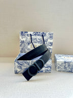 Black Dior belt with CD buckle centered on wide strap, resting flat.