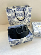 Black Dior belt with CD logo buckle on wide ribbed strap, side view.
