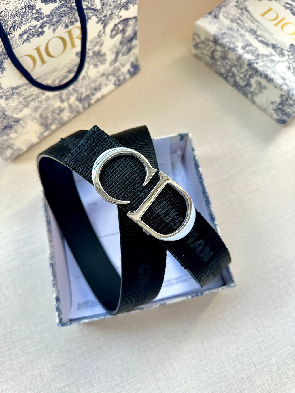 Navy web belt with silver CD buckle and textured strap detail