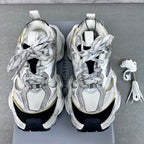 Unisex Balenciaga sneakers pair front view, silver laces, gold accents, thick black soles
