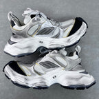 Unisex Balenciaga sneakers side view, silver upper with gold accents and black tread sole