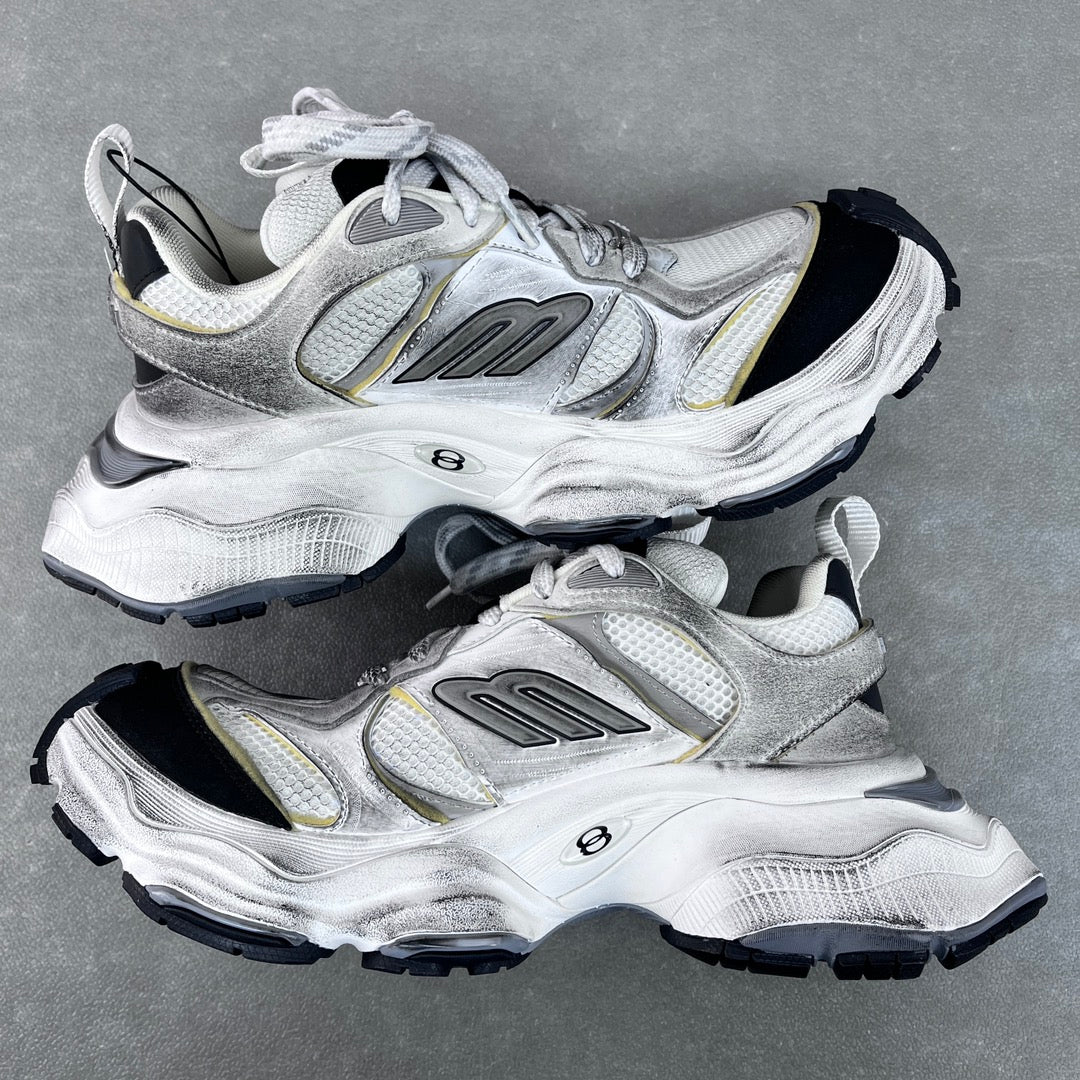 Unisex Balenciaga sneakers side view, silver upper with gold accents and black tread sole