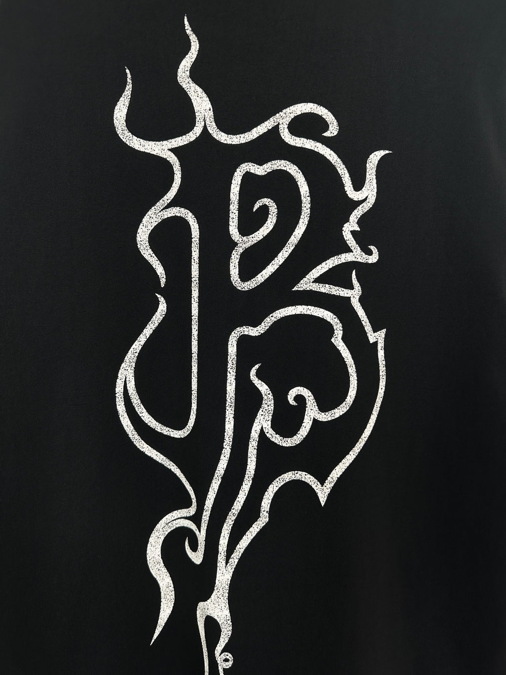 Black T-shirt close-up of white flame monogram print