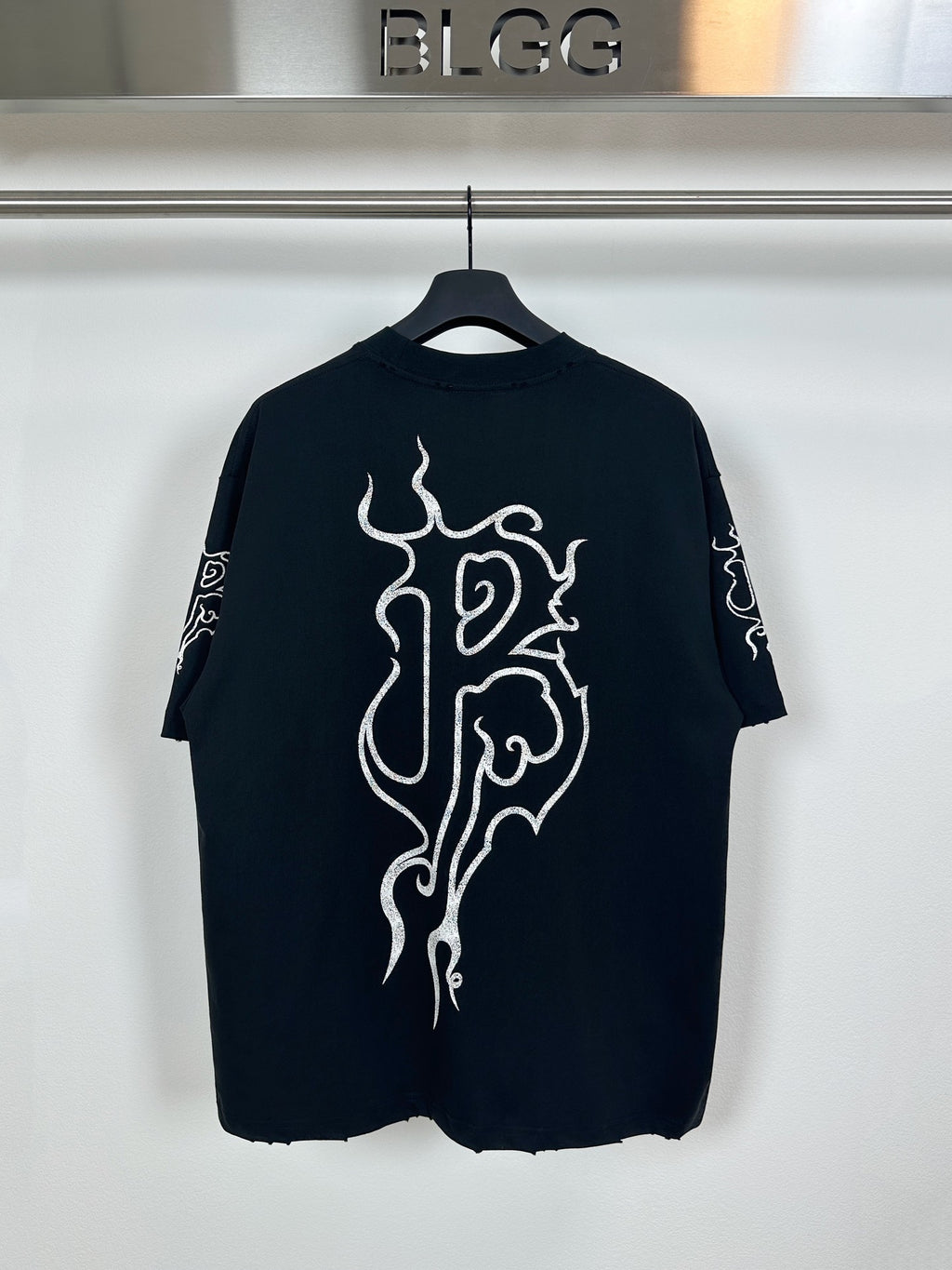 Black T-shirt with large white flame-style graphic on front