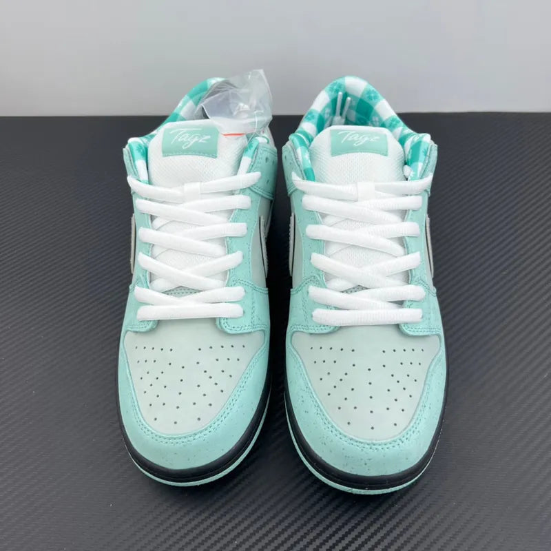 Front view of aqua and white sneakers with white laces and perforated toe box